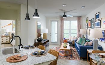 A living room with a kitchen and a dining room